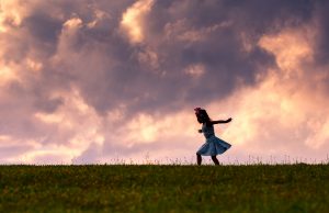Gorgeous magical sky with child on hill underneath