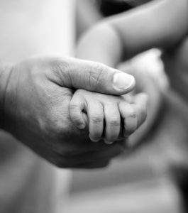 Dad and baby holding hands