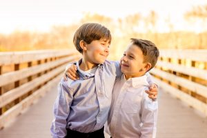 Boys looking at each other on wooden bridge