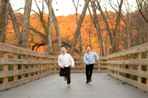 Boys running through leaves by Chattahoochee River