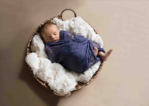 baby in basket asleep by window light