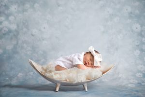 Baby Girl sleeping on blanket in wooden basket
