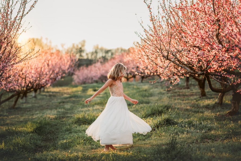 photo child twirling in peach field outside atlanta