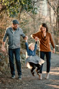 mom and dad swinging girl for family photo