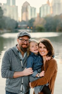 family portrait with midtown in background at Piedmont park