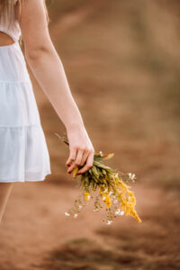 detail shot of senior holding wildflowers