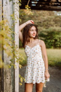 Creekview senior in a floral dress during her outdoor portrait session