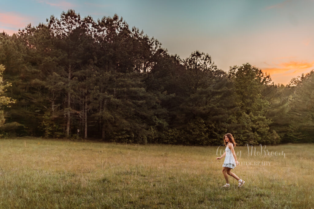 Creekview High School senior walking through a field at sunset at Birmingham Park