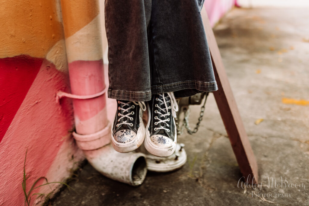 close up of doodled-on converse sneakers during senior session at mural wall
