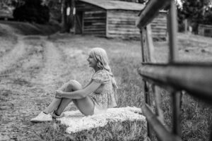Black and white senior pictures candid and natural by a fence