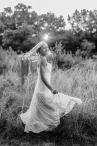 Black and white field senior portrait with movement and sunset light in East Cobb