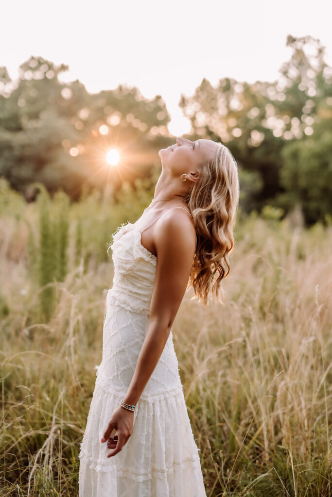 Pope High School senior in a white dress photographed at golden hour in an East Cobb field