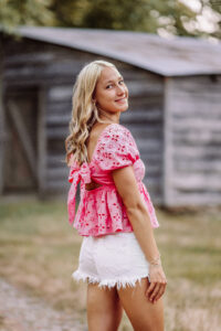 Casual Pope High School senior pictures with a rustic outdoor backdrop in Marietta