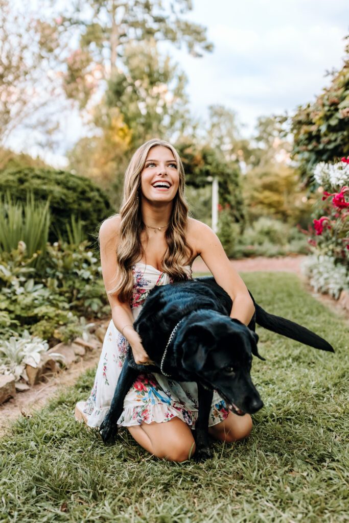 high school senior in Roswell hugging her wild dog and laughing during her session