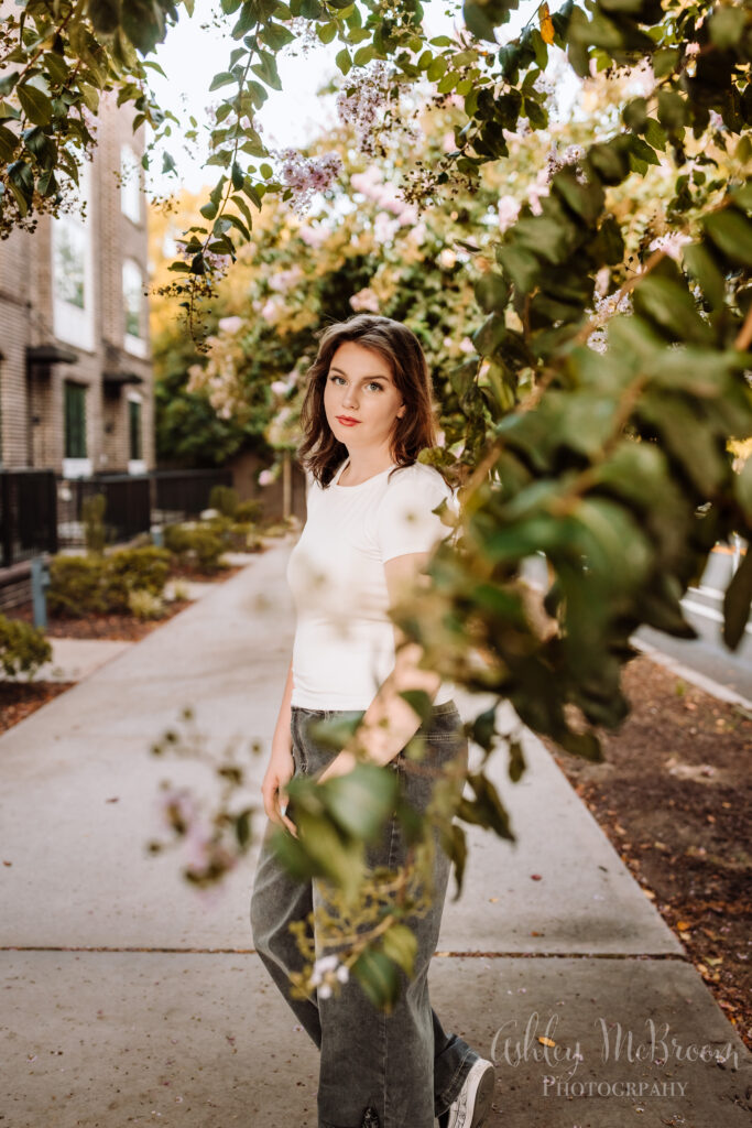 senior girl with blooming tree around her in urban location