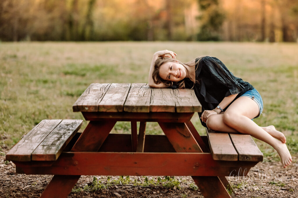 Walton senior leaning on picnic table