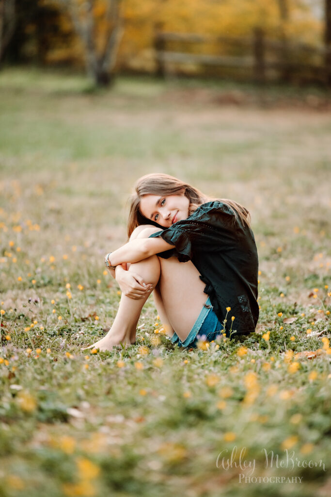 Walton High School senior pictures curled up in the grass barefoot
