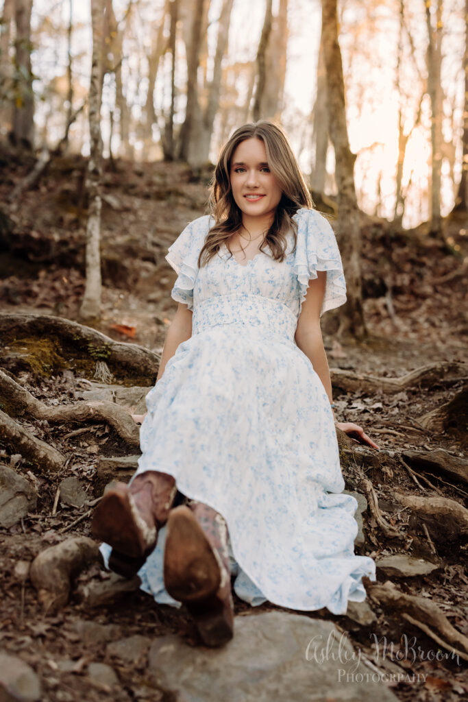 stunning Walton high school senior sitting in woods in east Cobb