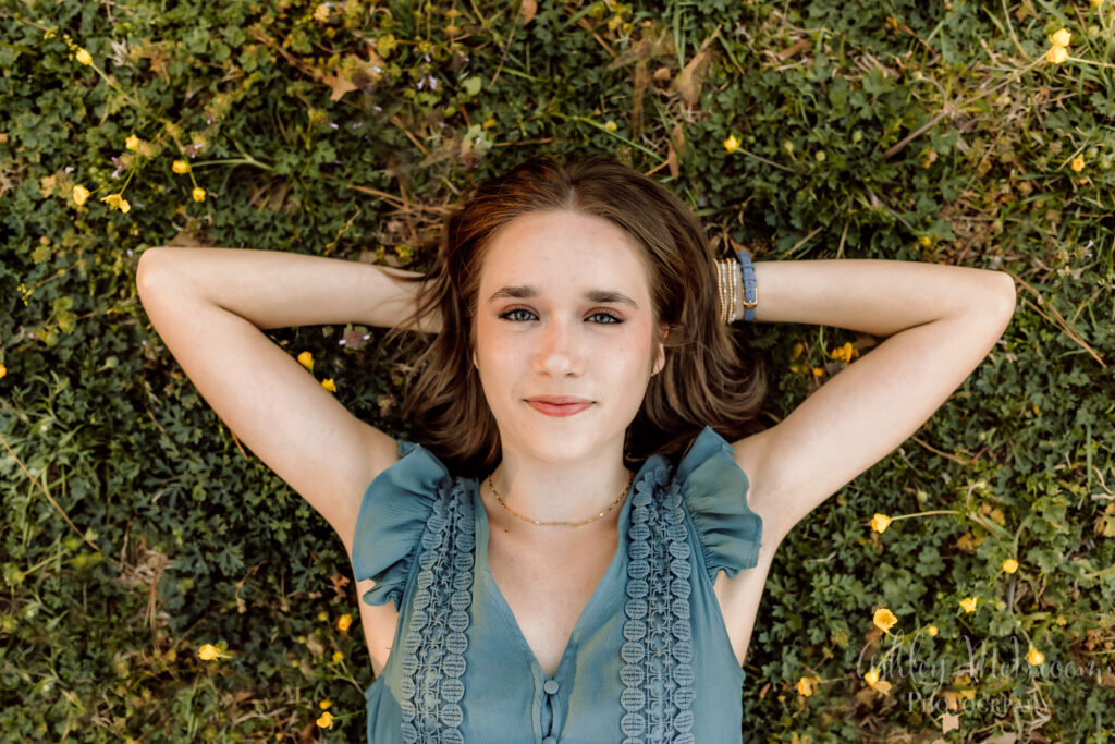 Walton senior laying in grass with hands behind her head